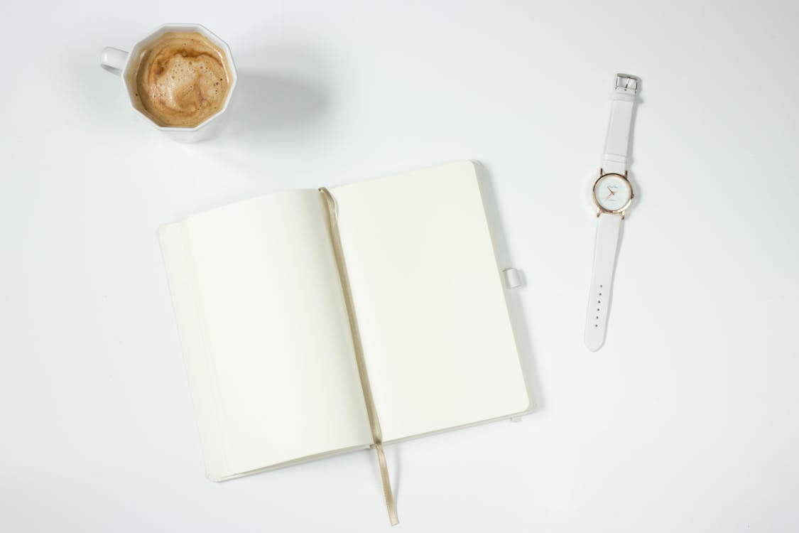 免費 筆記本旁邊的白色皮革錶帶銀色圓形模擬手錶 圖庫相片