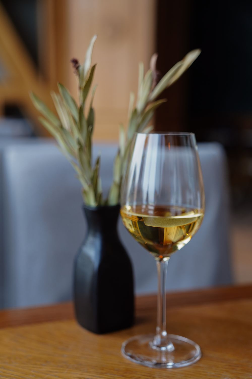 Pahar de vin alb pe o masă rustică de restaurant, într-un winstub alsacian