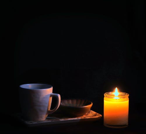 Flame on a Candle by a Mug and a Bowl