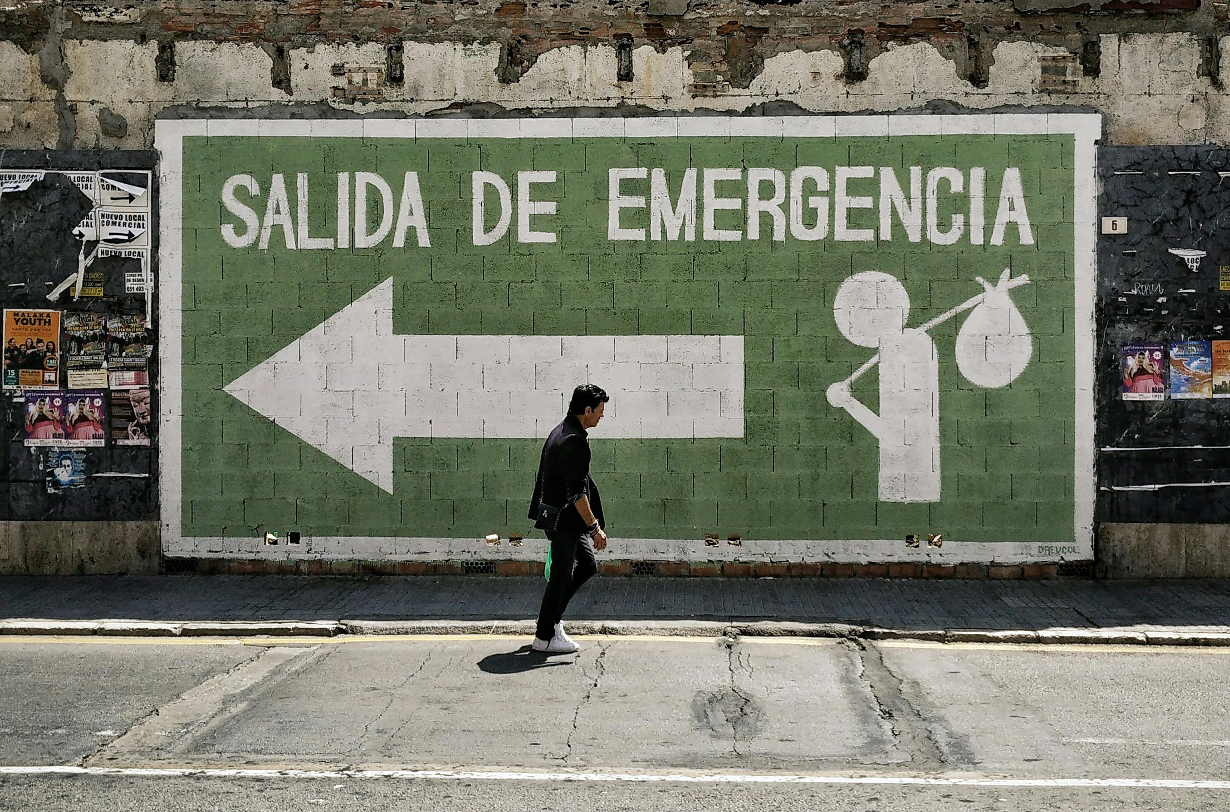 salida de emergencia emergency exit and man walking street in malaga spain