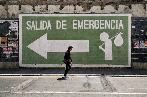 Salida de Emergencia (Emergency Exit) and man walking, street in Malaga, Spain