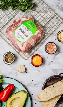 Fresh ingredients including meat, avocado, spices, and bread, perfect for gourmet cooking and food photography.