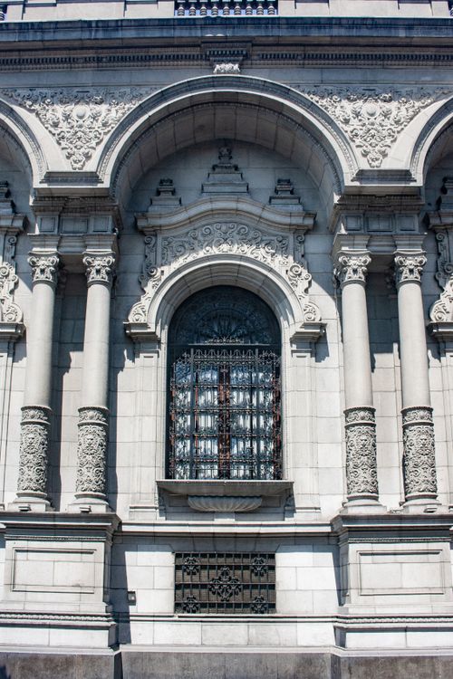 Free Detailed shot of an ornate architectural facade featuring columns, reliefs, and a decorative window. Stock Photo