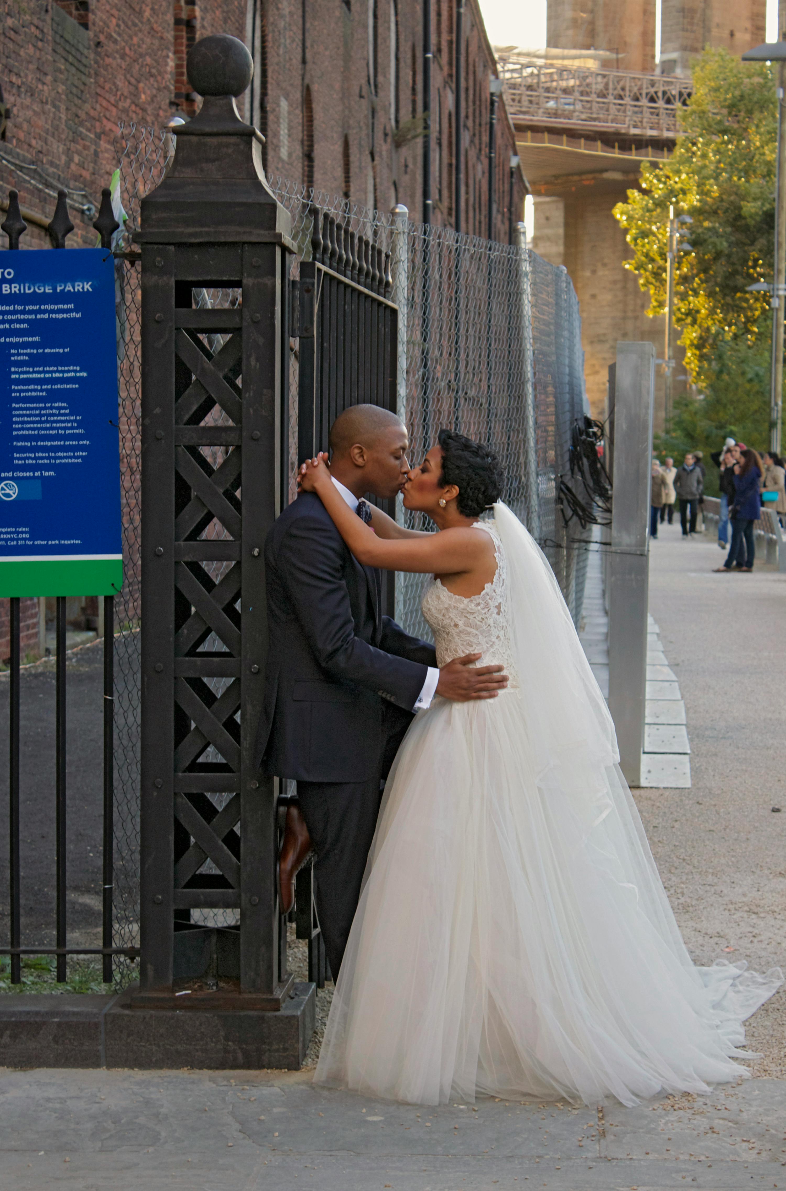 newlyweds kissing by wall