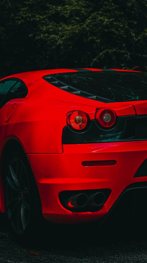 Free Rear view of a sleek red sports car showcasing its stylish taillight design. Stock Photo
