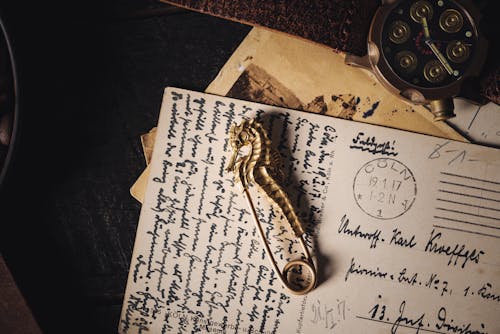 Brass Pin in Shape of Seahorse on Old Letter