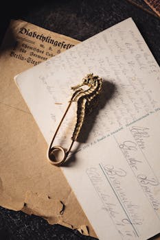 A vintage brass seahorse pin on an antique handwritten letter, exuding nostalgia.