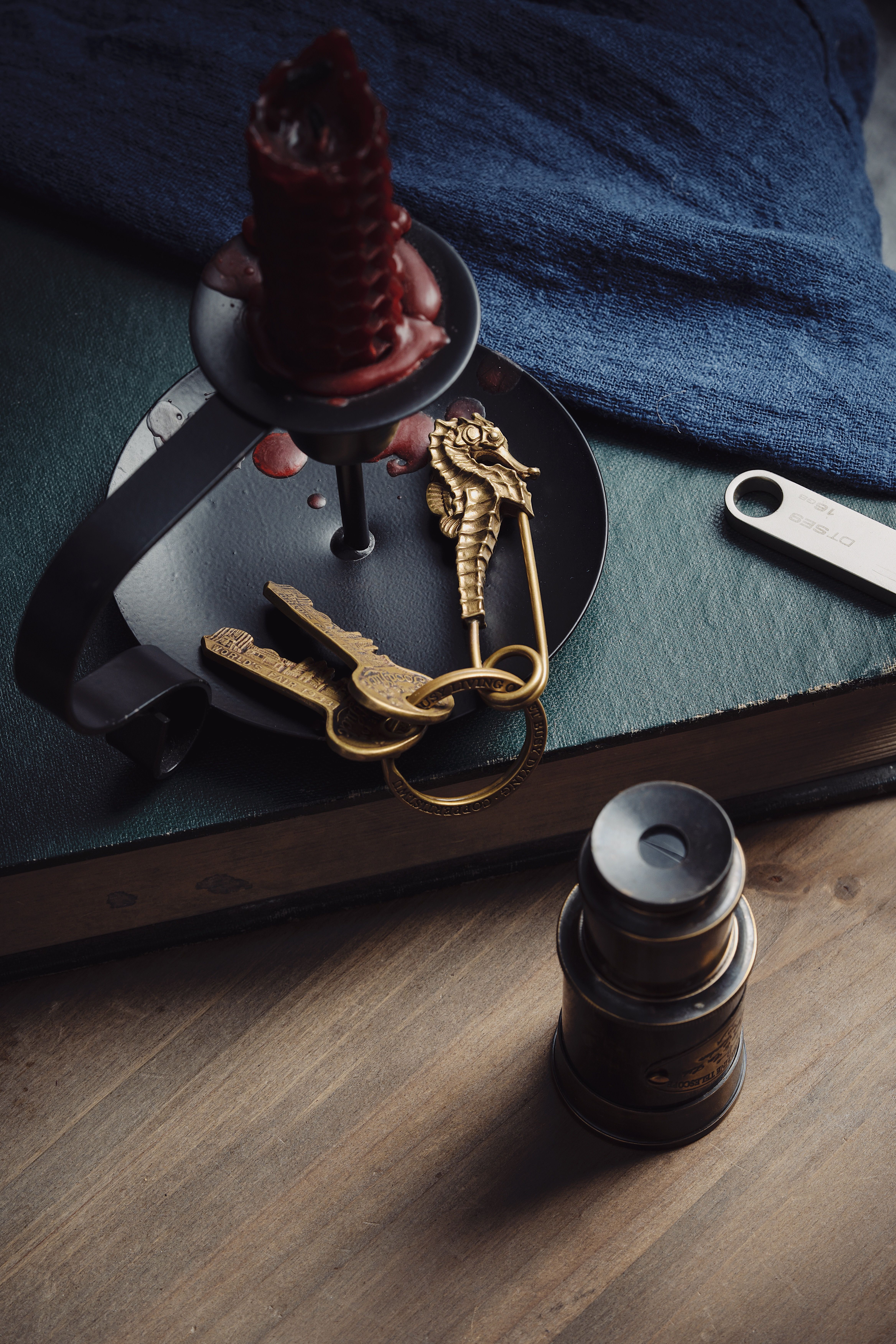 A small wooden desk with a brass key resting on a leather bound book