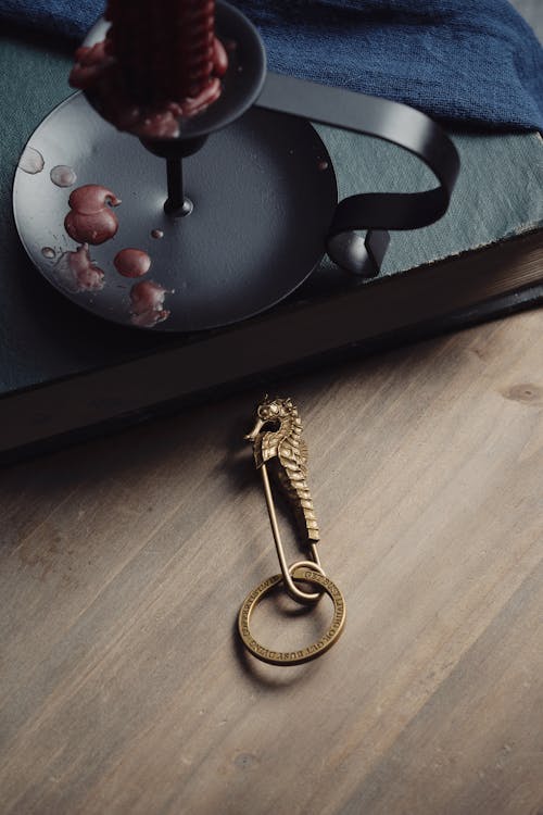 Pin with Ring by Red Candle on Desk