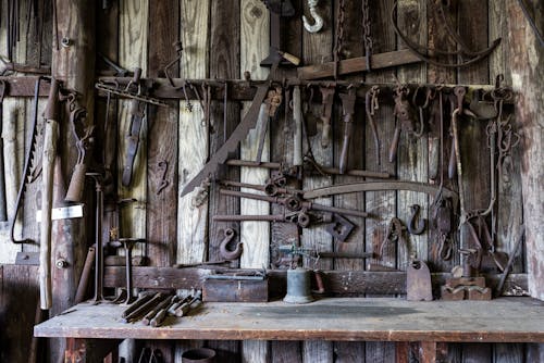 бесплатная Инструменты из черного металла, висящие на стойке возле стола Стоковое фото