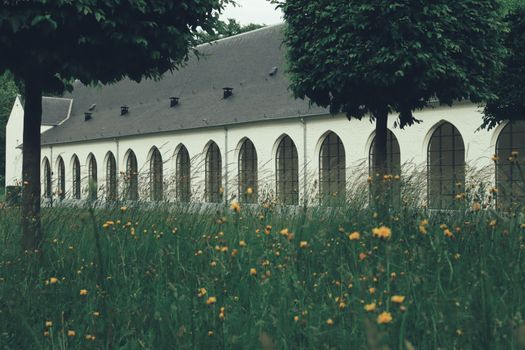 A large building with a white roof and a green field