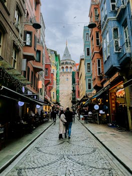 Colorful street in Istanbul featuring the historic Galata Tower surrounded by lively architecture.