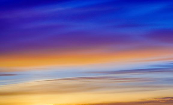 Captivating sunset sky with vibrant gradient from orange to blue hues.