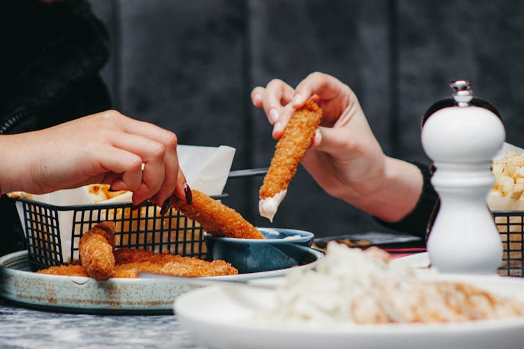 Couple Women Eating Chicken Fingers In Cafe