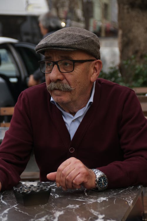 Elderly Man with Mustache Wearing Eyeglasses and a Peaked Cap 