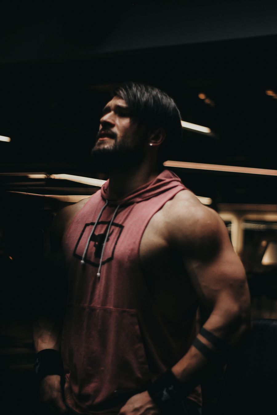 Entrenador fitness con hoodie en gimnasio