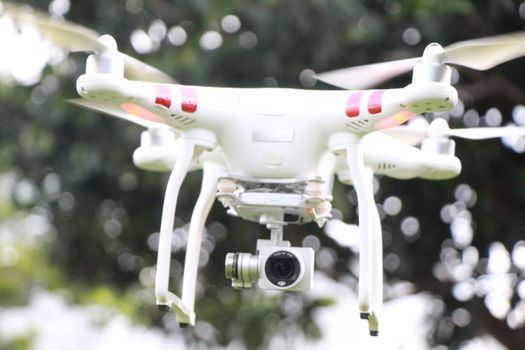 Close-up of a drone with camera flying outdoors, showcasing technology.