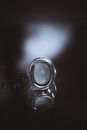 A close-up view of a monochrome gemstone ring with a glossy reflection.