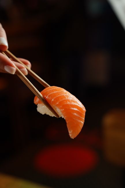 chopsticks holding marinated salmon