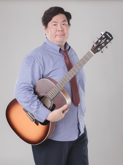 Kostnadsfri bild av asiatisk man, gitarr, håller