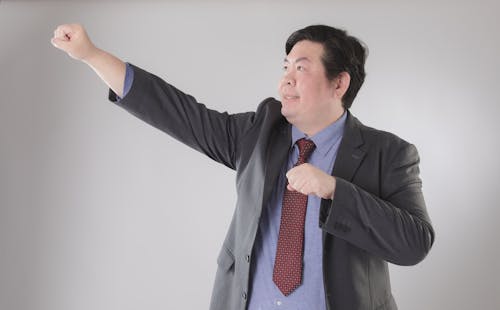 Man in Suit Posing with Arm Raised