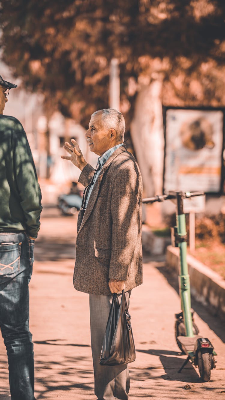 Man In Suit Standing On Sidewalk And Talking