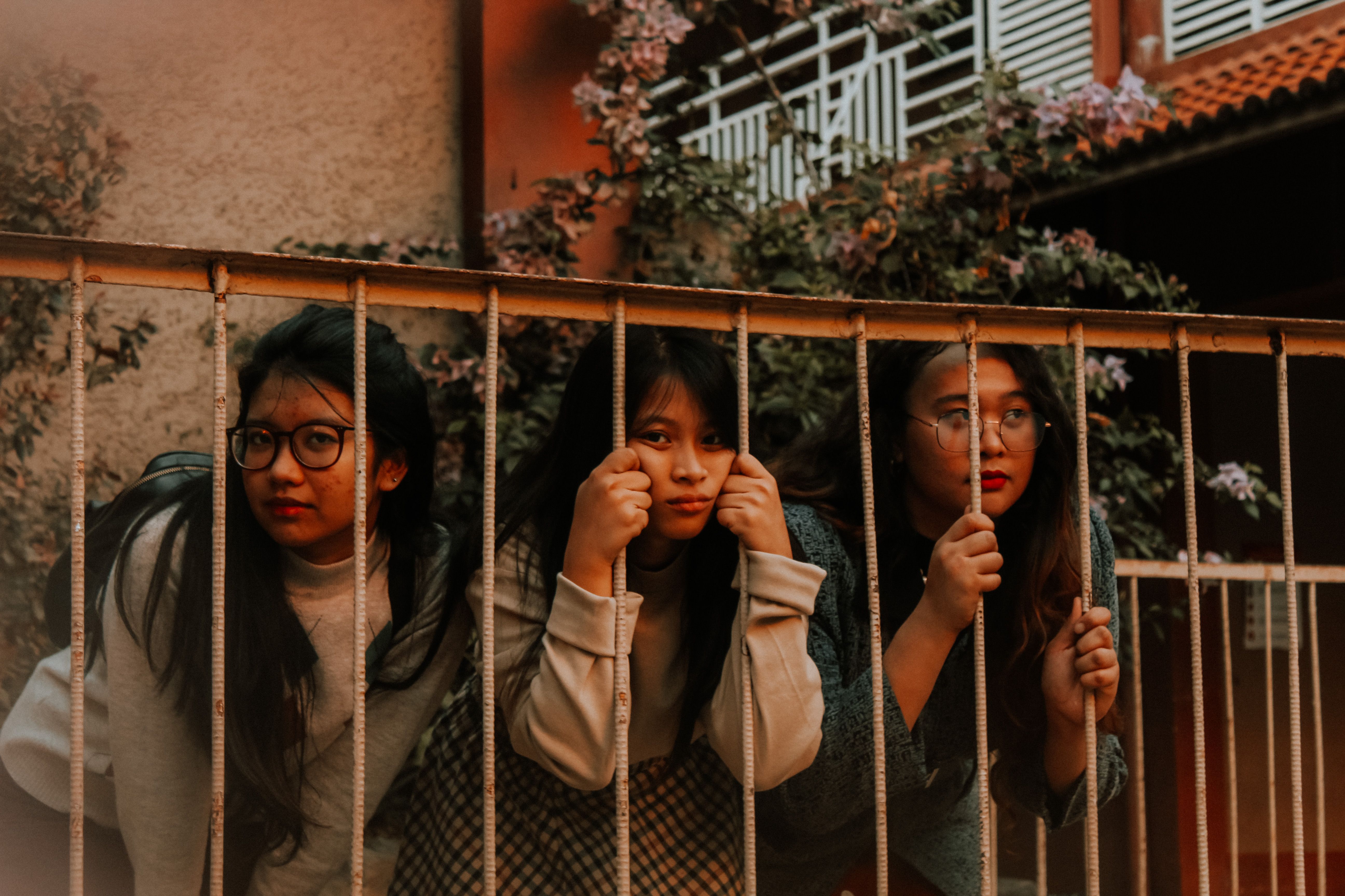 Women Posing behind Railing Bars · Free Stock Photo