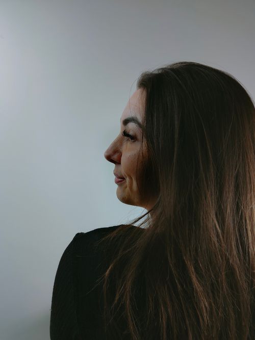 Free Portrait of a brunette woman in profile view against a neutral background. Stock Photo