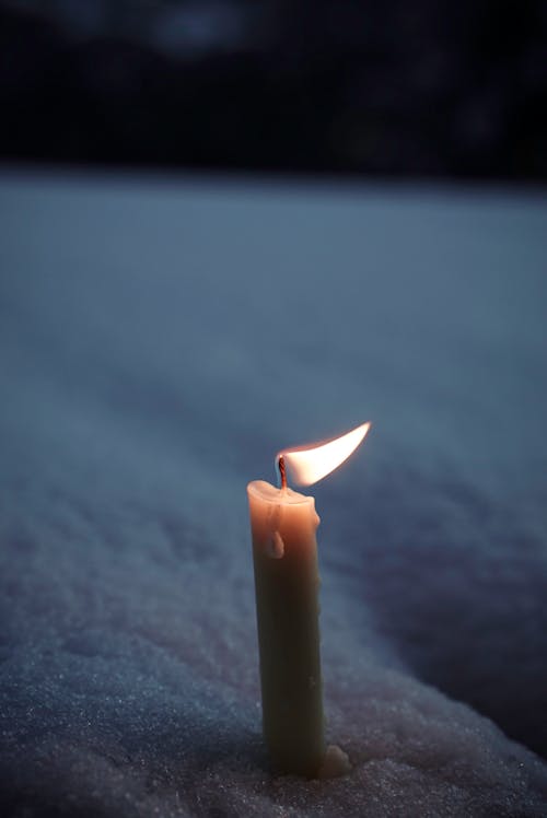 Wax Candle Burning in Snow