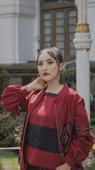 Fashionable Asian woman posing outdoors in red attire, showcasing modern style. - Fotografer Sidoarjo