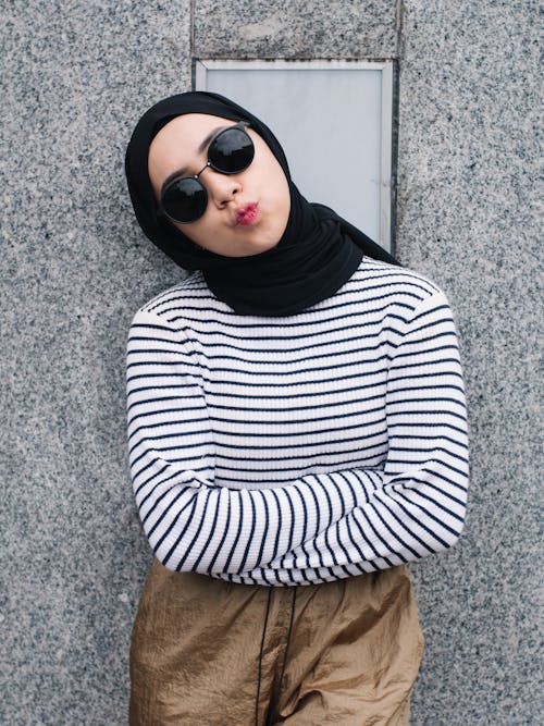 Young Woman in Sunglasses and Headscarf Pursing Her Lips