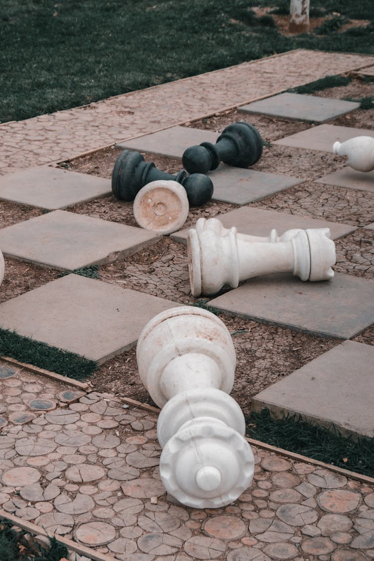 Fallen Chess Pieces On Pavement