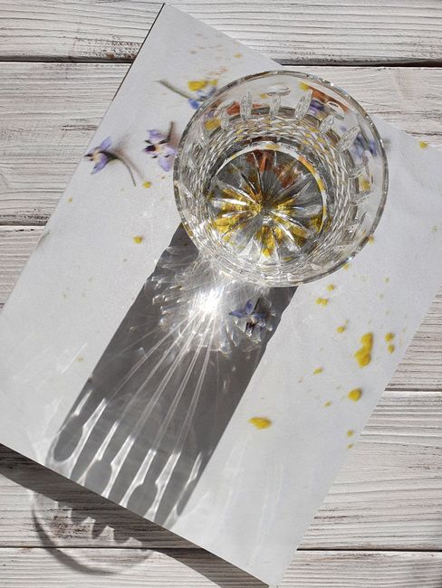 Crystal glass casting intricate shadows on floral backdrop, capturing elegance.