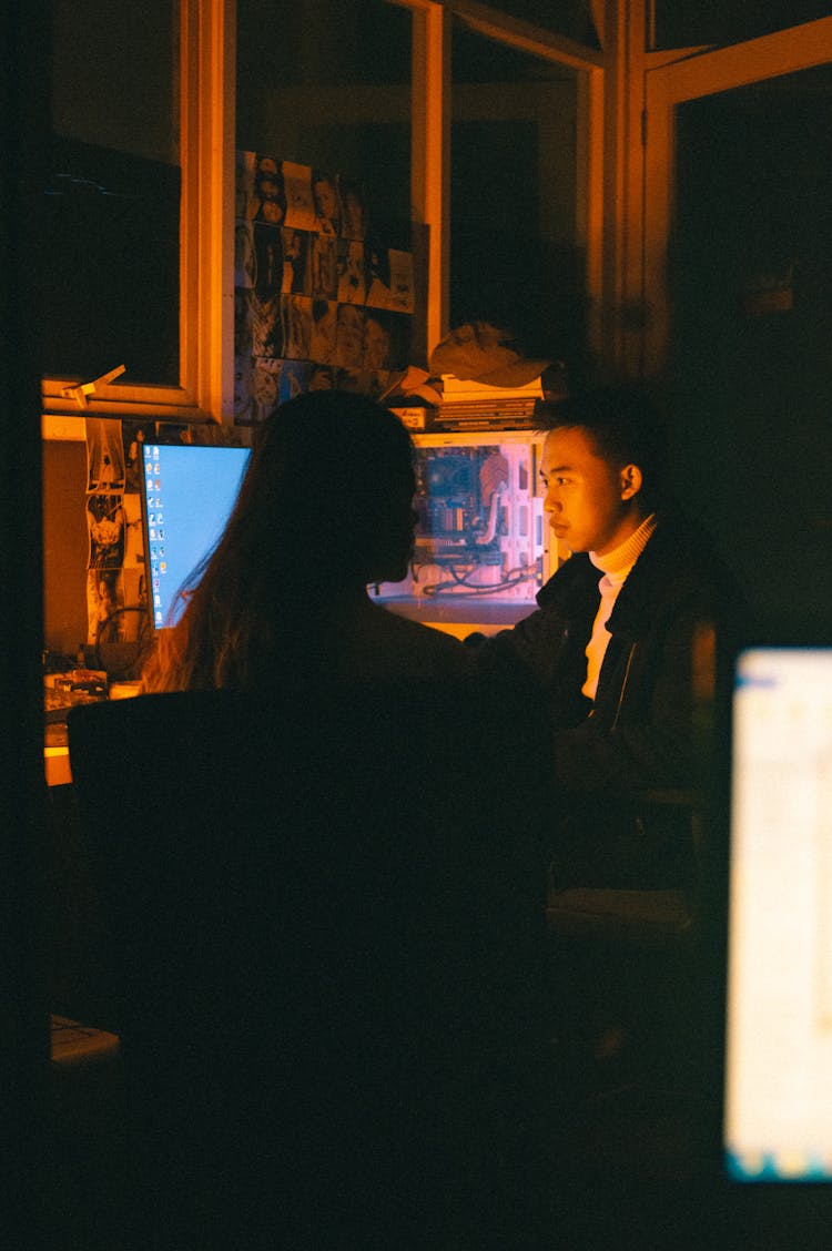 Woman And Man Sitting By Computer At Desk