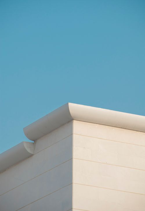Free Minimalist corner of a modern building with white walls against a clear blue sky in Dubai. Stock Photo