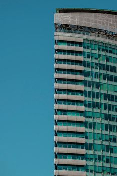 Striking view of a contemporary skyscraper set against a vibrant blue sky in Dubai.