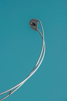 Elegant modern street lamp with a clear blue sky backdrop highlighting urban architecture.