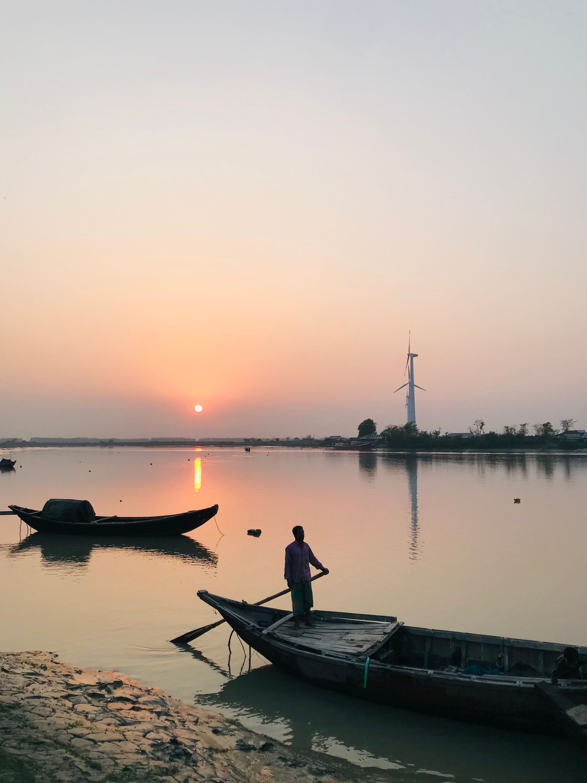 Pescador ao amanhecer em lago com neblina