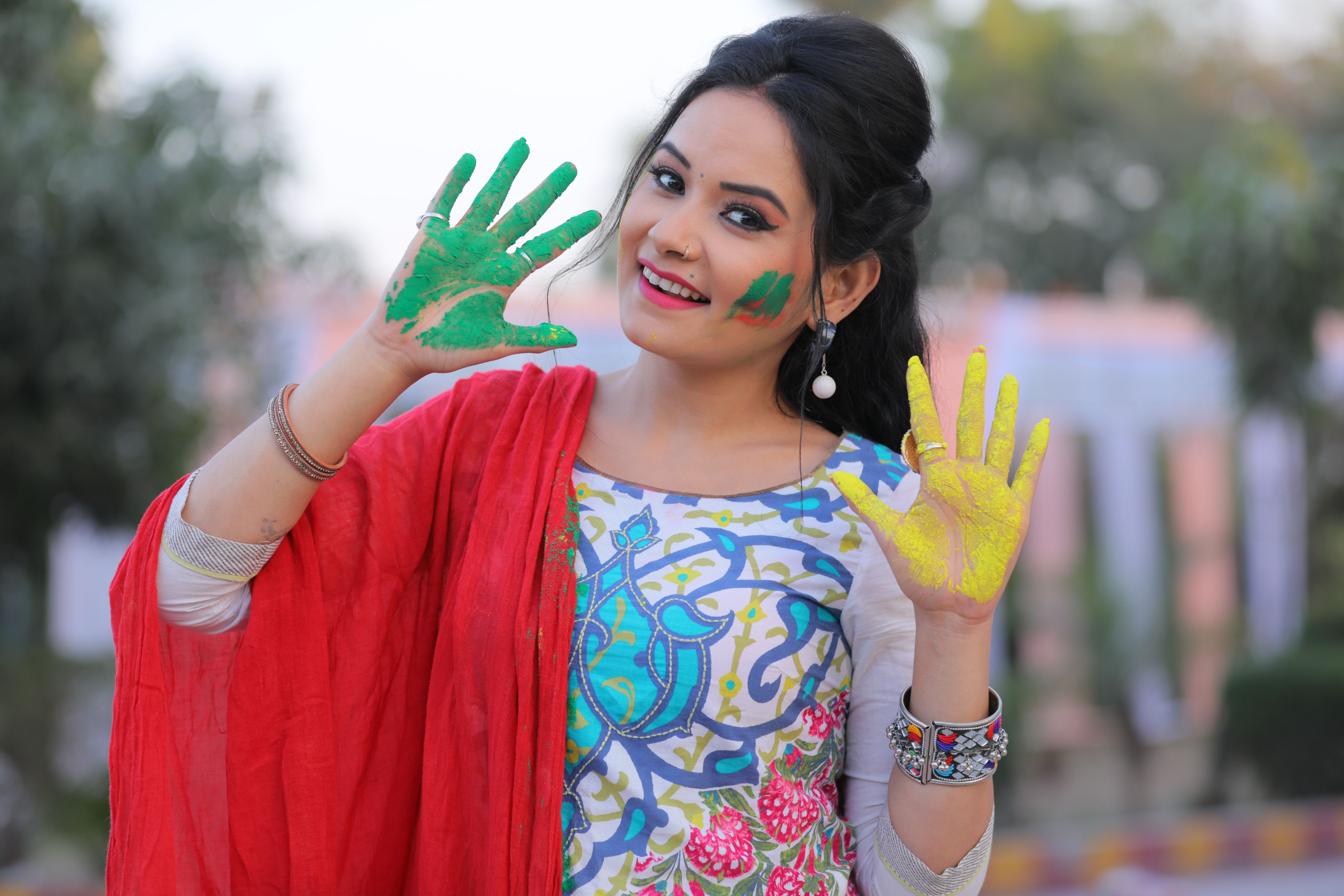Smiling Woman in Traditional Dress with Colorful Palms · Free Stock Photo
