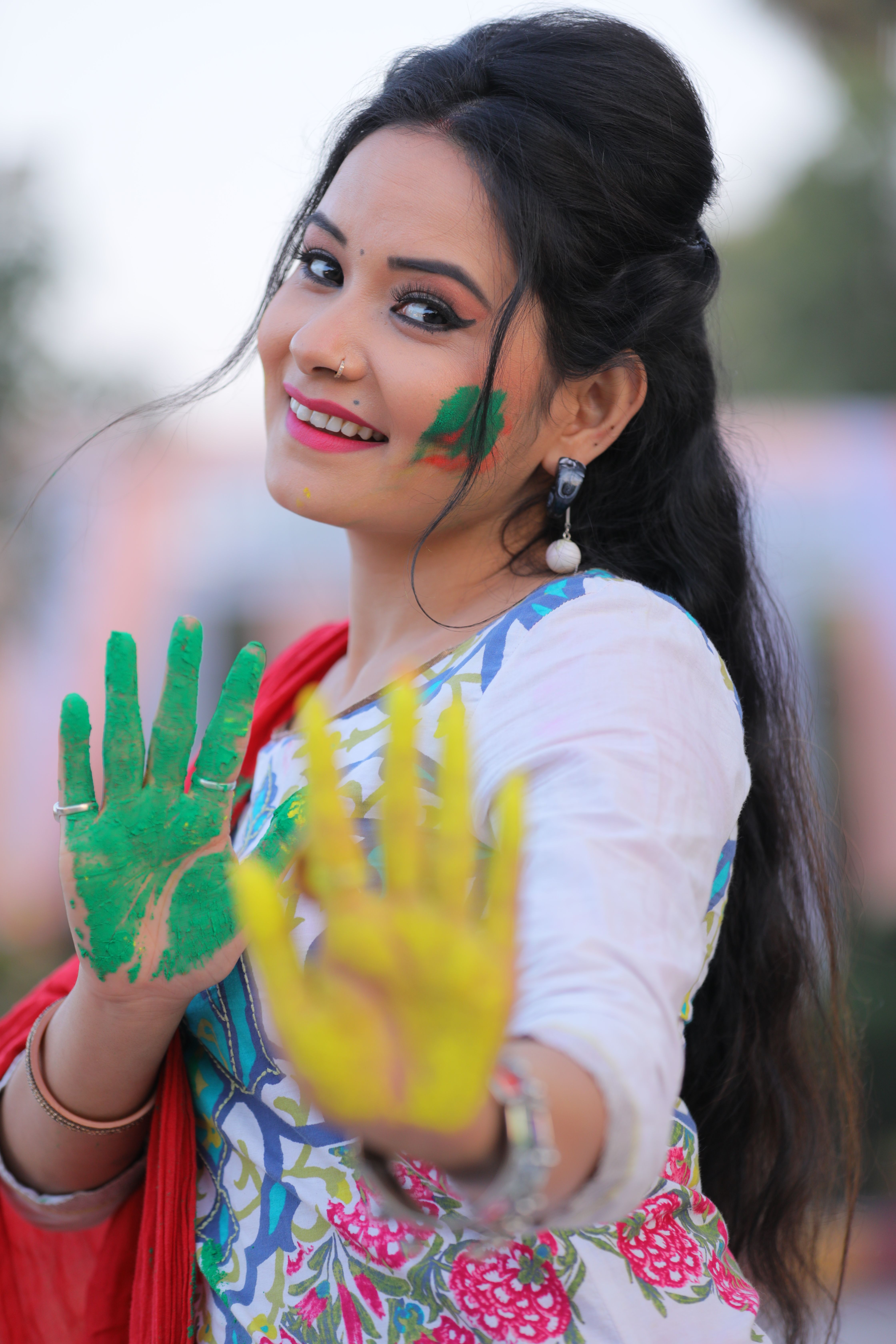 Smiling Woman with Colorful Palms Posing Outdoors · Free Stock Photo