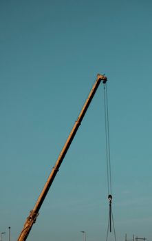 A construction crane towers against the clear blue sky in Dubai, UAE, symbolizing urban growth.