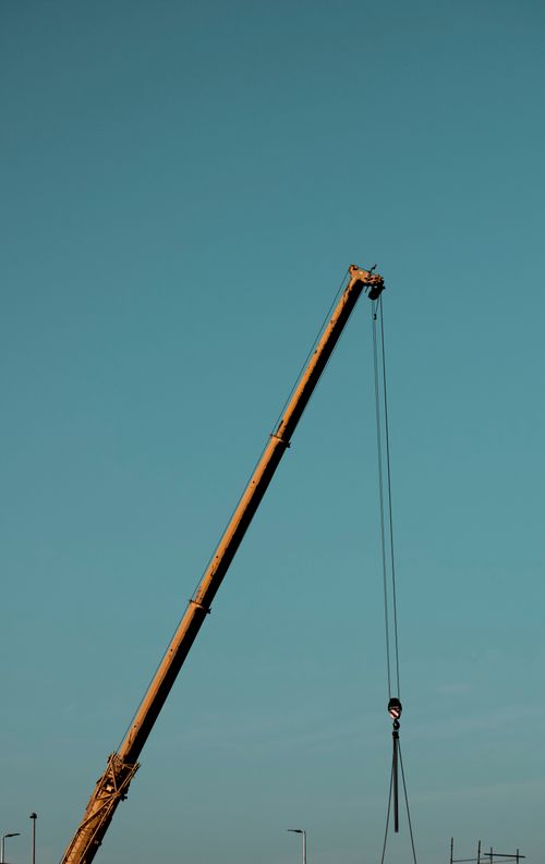 Free A construction crane towers against the clear blue sky in Dubai, UAE, symbolizing urban growth. Stock Photo