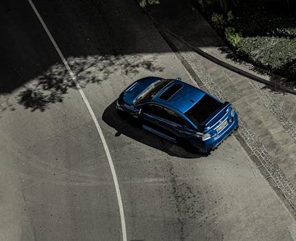 High-angle view of a blue sports car on a city street in Dubai, UAE.