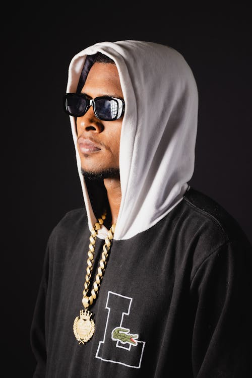 Man in Sunglasses and Hoodie Posing on Black Studio Background