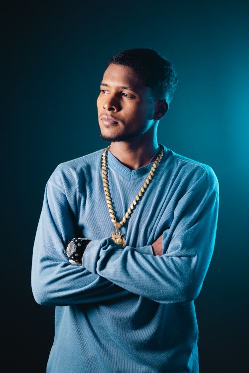 Free Portrait of a man in blue sweater with arms crossed, exuding charisma and style. Stock Photo