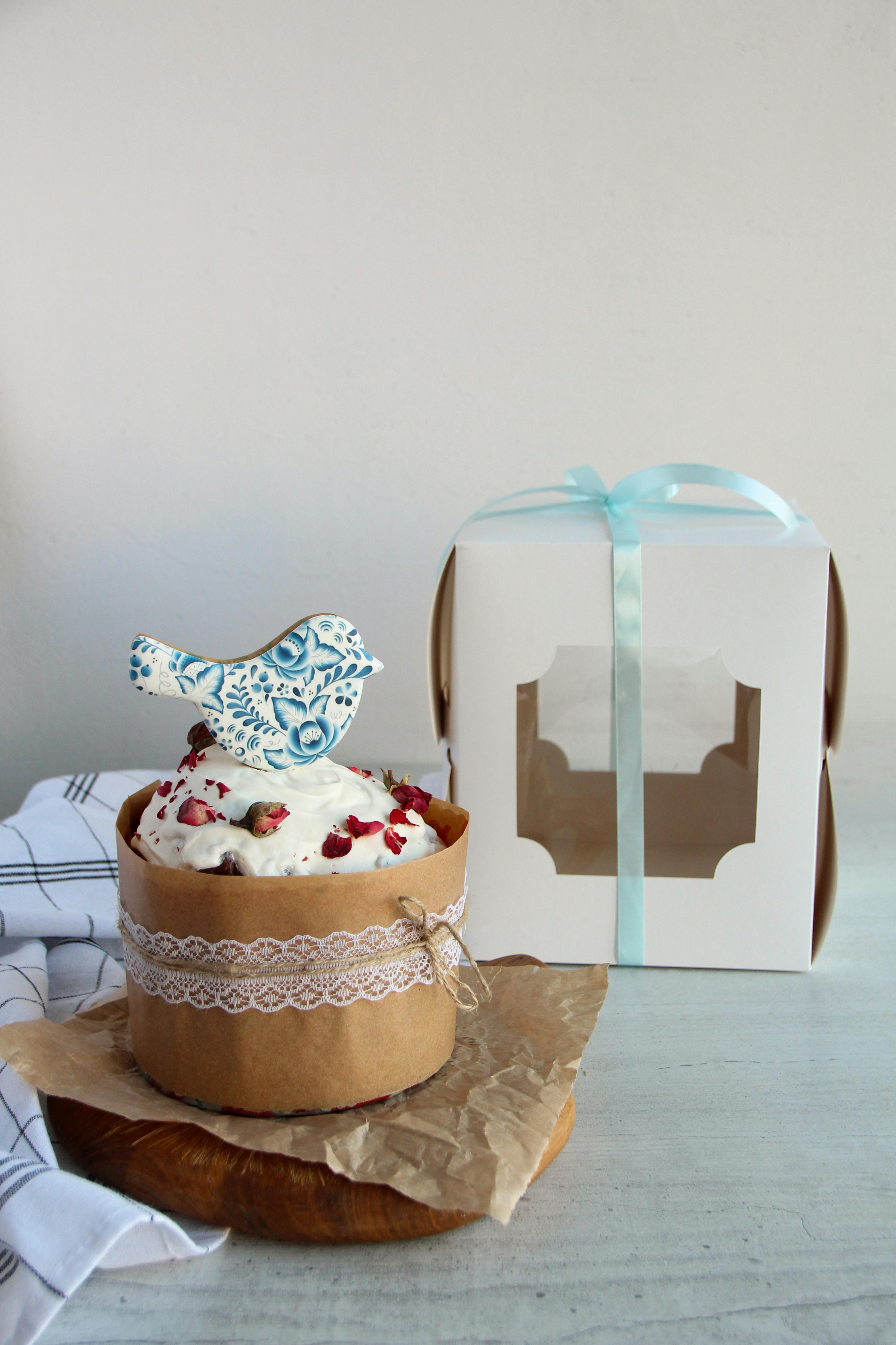 A beautifully decorated Easter cake with a bird topper, perfect for festive occasions.