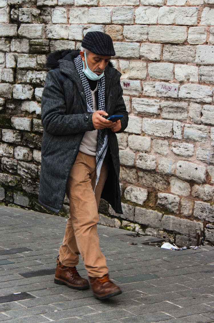 Old Man Walking On Paved Street