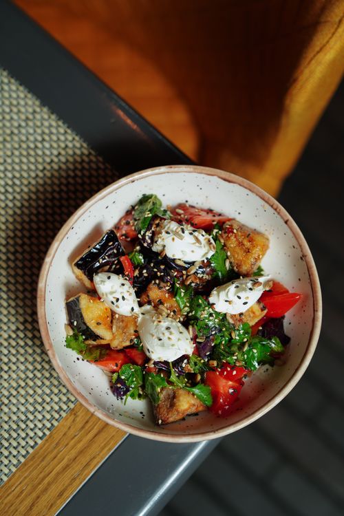 Free Delicious Mediterranean salad topped with goat cheese and fresh vegetables, perfect for a healthy meal. Stock Photo