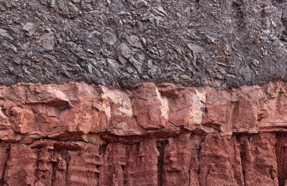 Closeup view of stratified rock layers showing distinct textures and colors.