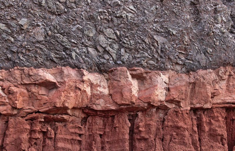 Stratified rock layers exposed in a cliff face. Photo by Miguel Delima on Pexels.